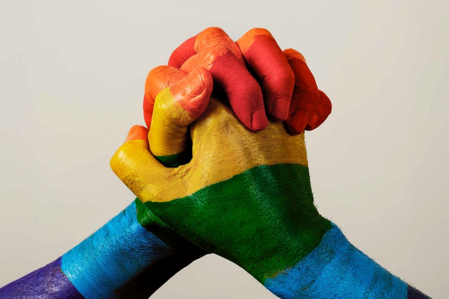 Regenbogenfarbene Hände greifen ineinander